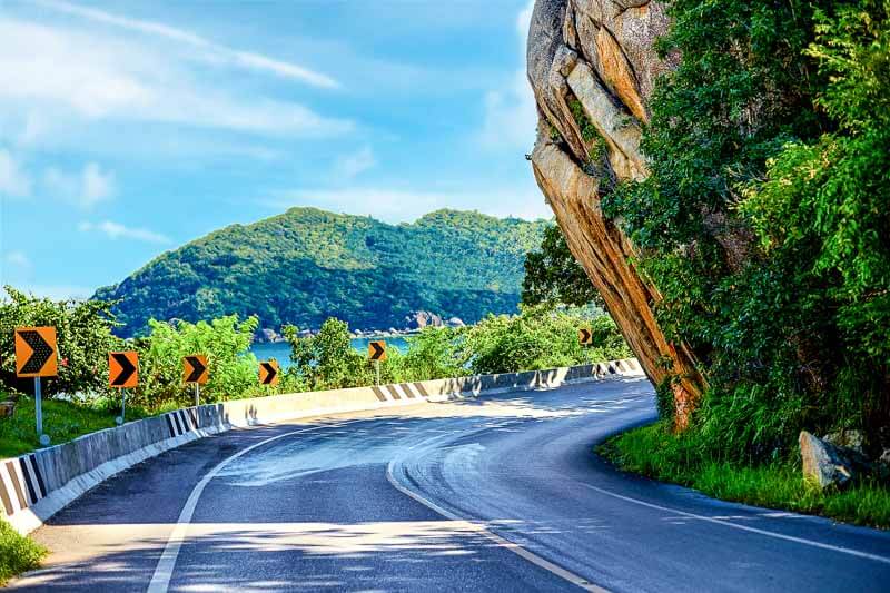 Coastal road in Koh Samui winding through lush greenery.